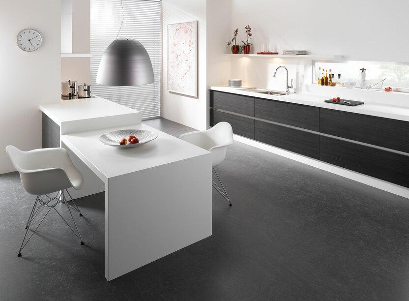 Impression einer Küchengestaltung mit Essplatz für Zwei Impression einer einzeiligen Küchengestaltung in schwarz-weiß mit Esstisch für Zwei