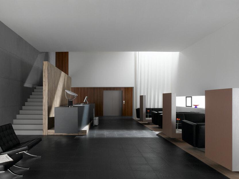 Hotelappartment Untergeschoss mit Holzmobiliar, dunklem Parkett und Treppenaufstieg