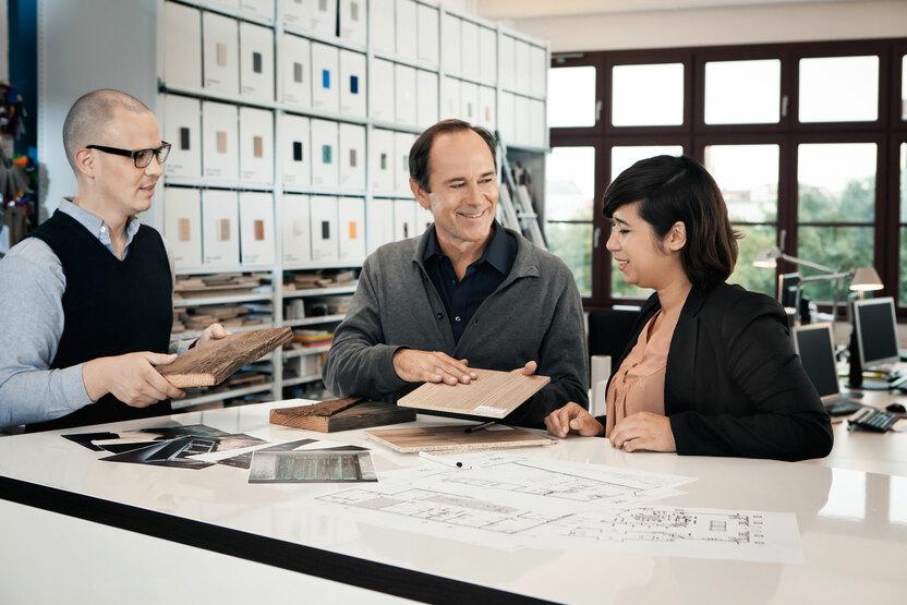 Beratung zu verschiedenen Holzoberflächen zwischen Berater und Eheleuten