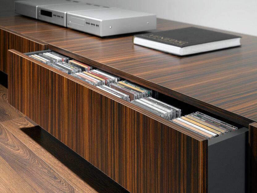 Detailaufnahme eines lackierten Sideboards mit offener Schublade für CD-Aufbewahrung